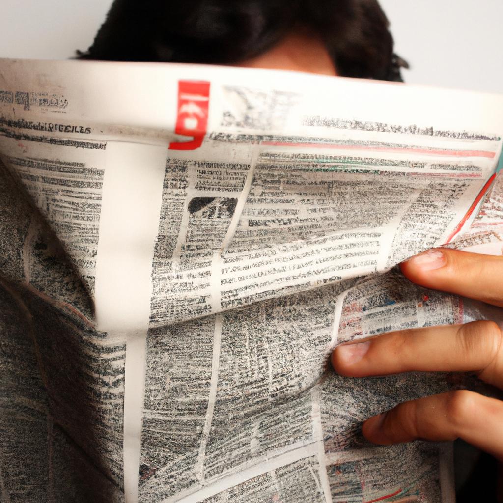 Person holding newspaper, reading attentively